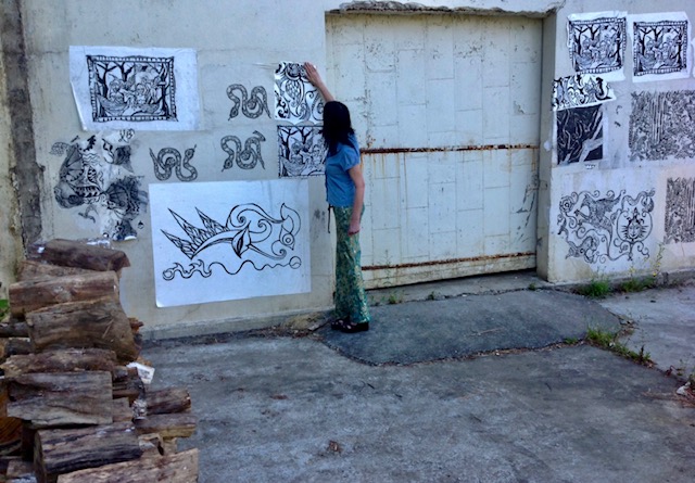 Darbury in front of wall with prints.